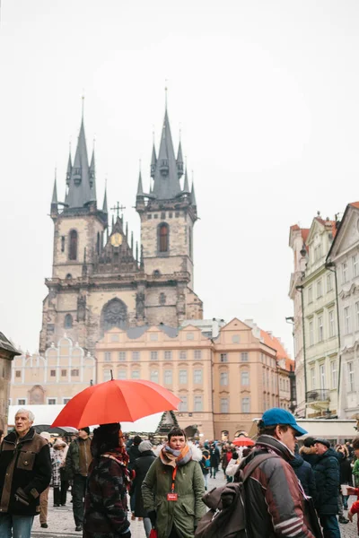 Praga, 13 de diciembre de 2016: Una guía con un paraguas rojo tradicional en la Plaza de la Ciudad Vieja de Praga invita a los turistas a visitar los lugares de interés. Turismo en Navidad. República Checa. Europa . — Foto de Stock