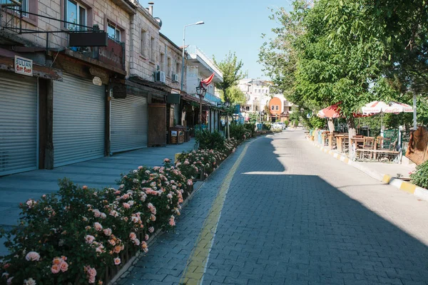 Türkei, Kappadokien, Goreme, 12. Juni 2017: sonniger Morgen in Goreme - Straße mit Blumen und geschlossenen Geschäften und leeren Straßencafés — Stockfoto