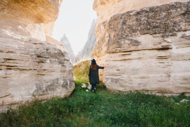 Kadın güzel kayaların arasına standları ve peyzaj Kapadokya Türkiye'de hayran