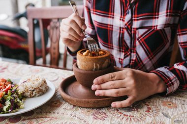 Bir restoran ziyaretçi Tüketilmekte olan spesiyal kebap aramadan önce bozuldu bir tencerede bir ulusal Türk yemek yiyor. Restoran yemek ile.