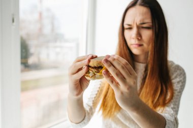 Bir genç kız o hamburger gibi değil gösterir. Sağlıksız yeme ret kavramsal görüntü.