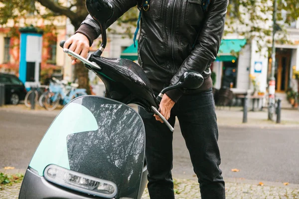Турист сел на электрический скутер. Популярный автомобиль в городе называется электрическим скутером. На заднем плане улица в Берлине . — стоковое фото