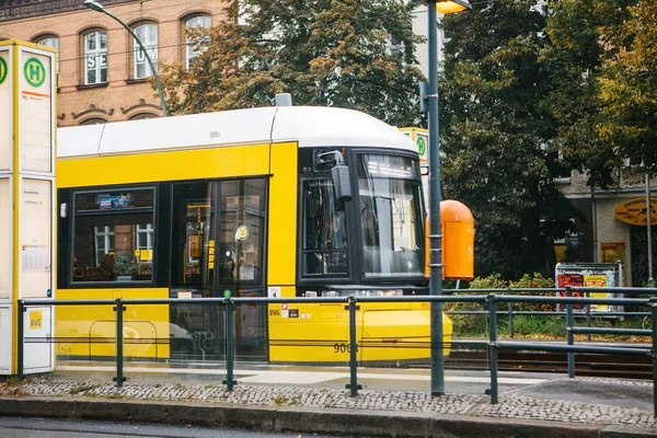 Berlin, October 2, 2017: City public transport in Germany. Beautiful black and yellow train stopped at stop on the background of an old building — Stock Photo, Image