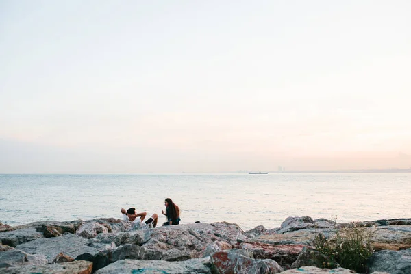 Istanbul, 14. Juni 2017: zwei Freunde sitzen an der Küste in der Nähe des Meeres, kommunizieren und genießen den Blick auf den Bosporus und Istanbul. Ruhe, Freundschaft, Urlaub. — Stockfoto