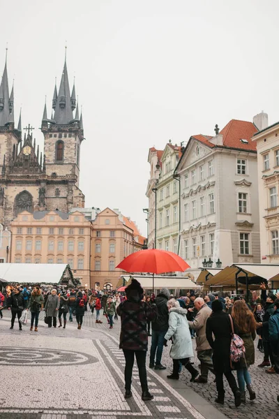 Praga, 13 de diciembre de 2016: Una guía con un paraguas rojo tradicional en la Plaza de la Ciudad Vieja de Praga invita a los turistas a visitar los lugares de interés. Turismo en Navidad. República Checa. Europa . — Foto de Stock