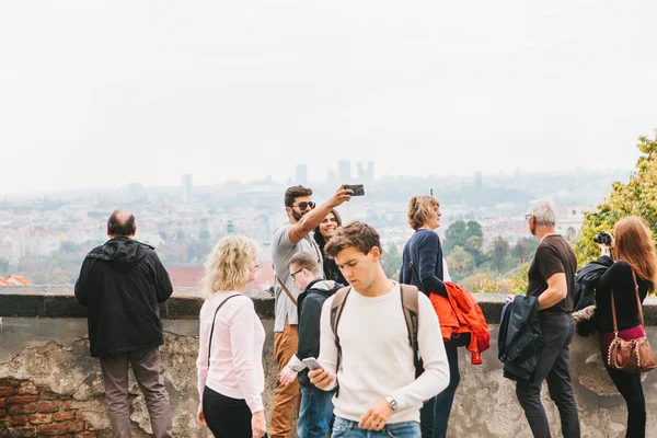 Prague, October 28, 2017: Tourists of different ages take photos and admire the view of Prague next to Prague Castle — Stock Photo, Image