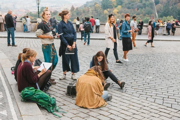 Прага, 28 октября 2017 года: Творческие молодые девушки - художницы рисуют картины на улице рядом с Пражским градом — стоковое фото