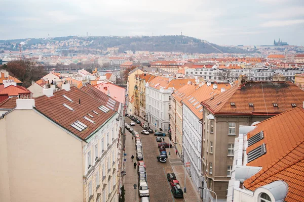 Pohled z nejvyššího bodu. Krásný pohled shora na ulic, silnic a střechy domů v Praze. Tradiční staré městské architektury. Na silnici, auto je zaparkované, obyčejný život. — Stock fotografie