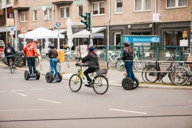 Berlin, 3 Ekim 2017: Gezi sırasında gyroscooters boyunca Berlin sokaklarında sürme turist grup. Bisikletçiler yanında biniyor.