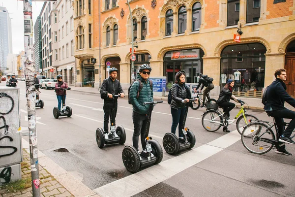 Berlin, October 3, 2017: Group of tourists riding on gyroscooters along the streets of Berlin during excursion. Cyclists are riding alongside. — Stock Photo, Image