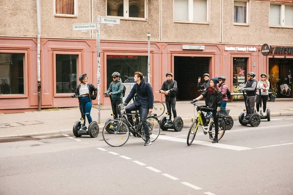 Berlin, October 3, 2017: Group of tourists riding on gyroscooters along the streets of Berlin during excursion. Cyclists are riding alongside. — Stock Photo, Image