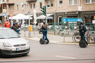 Berlin, 3 Ekim 2017: Gezi sırasında gyroscooters boyunca Berlin sokaklarında sürme turist grup. Arabayı yanında.