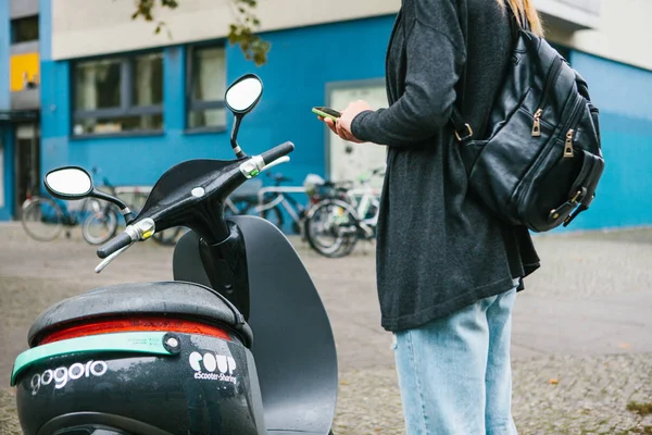 Berlin, October 1, 2017: Escooter activated through a mobile phone application. A tourist is going to use an electric scooter through a mobile application in the phone and distally activate it. — Stock Photo, Image