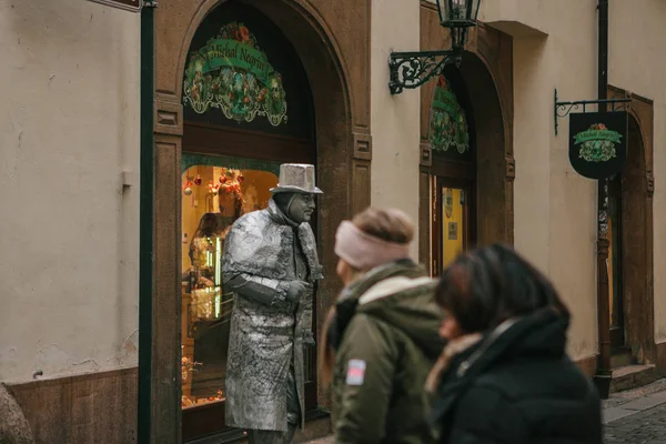 Praga, Republika Czeska - 13 grudnia 2016: człowiek pomnik, który stoi na ulicach Pragi. Turystów na ulicy w Pradze. Wakacje, wczasy, atrakcje. — Zdjęcie stockowe