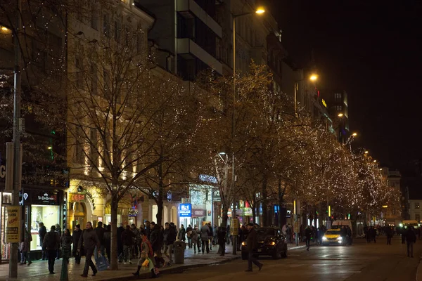Prag, 13. Dezember 2016: nächtliche Weihnachtsdekoration des Hauptplatzes. Straßengeschäfte und Menschen gehen nebenher. Weihnachten in Europa. — Stockfoto