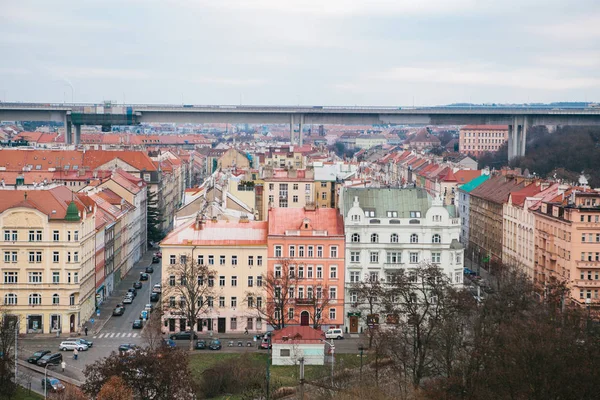 Vista desde un punto alto. Una hermosa vista desde arriba en las calles, carreteras y techos de casas en Praga. Arquitectura urbana antigua tradicional. La carretera, el coche está aparcado, la vida ordinaria . — Foto de Stock