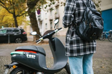 Berlin, 1 Ekim 2017: cep telefonu uygulaması harekete geçirmek Escooter. Bir turist bir mobil uygulaması aracılığıyla bir elektrikli scooter telefondaki kullanın ve klemple etkinleştirmek için gidiyor.
