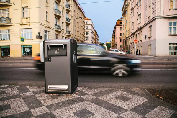 Un moderno bote de basura inteligente en la calle en Praga en la República Checa. Recogida de residuos en Europa para su posterior eliminación. Recogida de residuos respetuosos del medio ambiente. En el fondo el coche está en movimiento . — Foto de Stock