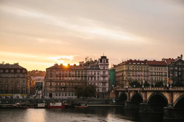 Schöne Aussicht auf die Architektur Prags in der Tschechischen Republik bei Sonnenuntergang. Traditionelle Häuser und eine Brücke über die Moldau. — Stockfoto