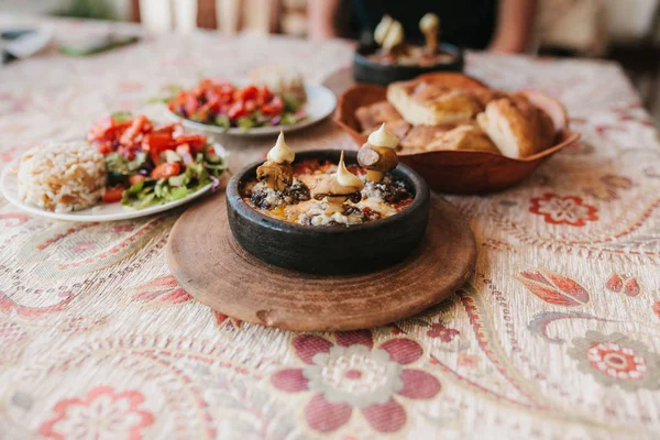 Danie z grzybów i białym sosie w misce na drewniany stojak. Tradycyjne dania kuchni tureckiej. — Zdjęcie stockowe