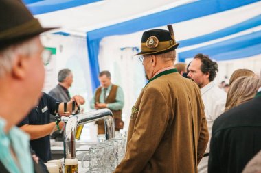 Prag, 23 Eylül 2017: Oktoberfest Çek Cumhuriyeti denilen geleneksel Alman Bira Festivali kutluyor. Geleneksel giysiler ve bir şapka bir adam Alman bira satın almak için sırada bekliyor.