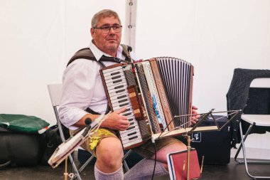 Prag, 23 Eylül 2017: Çek Cumhuriyeti'nde geleneksel Alman Bira Festivali Oktoberfest kutlamaları. Yaşlı sanatçı harmonies çalış ve eğlendirir ziyaretçi.