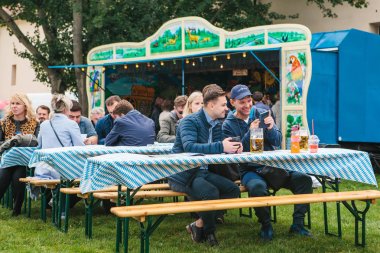 Prag, 23 Eylül 2017: Çek Cumhuriyeti'nde geleneksel Alman Bira Festivali Oktoberfest kutluyor. İki arkadaş birlikte bira içip birbirlerine telefonda fotoğrafları gösterilen oturmak