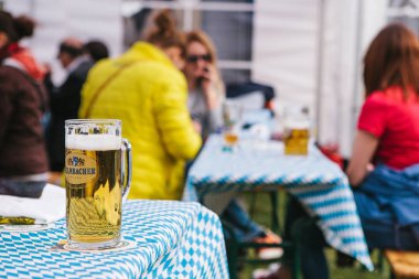 Prag, 23 Eylül 2017: Oktoberfest Çek Cumhuriyeti denilen geleneksel Alman Bira Festivali kutluyor. Bir bardak light bira. Arka planda, bulanık arkadaşlar ve konuşma taze iç