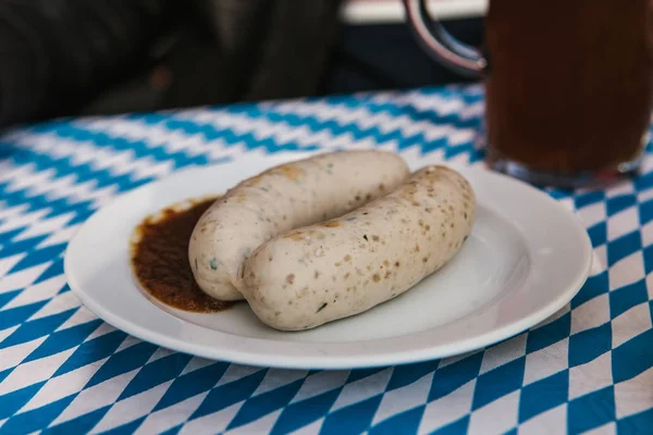 Traditional Bavarian sausages on a plate with sauce. Celebrating the traditional German beer festival Oktoberfest — Stock Photo, Image