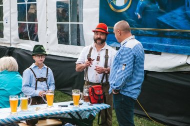Prag, 23 Eylül 2017: Çek Cumhuriyeti'nde geleneksel Alman Bira Festivali Oktoberfest kutluyor. Baba oğul yakın duruyor arkadaşı ile iletişim kurar. Bira çok yakın.