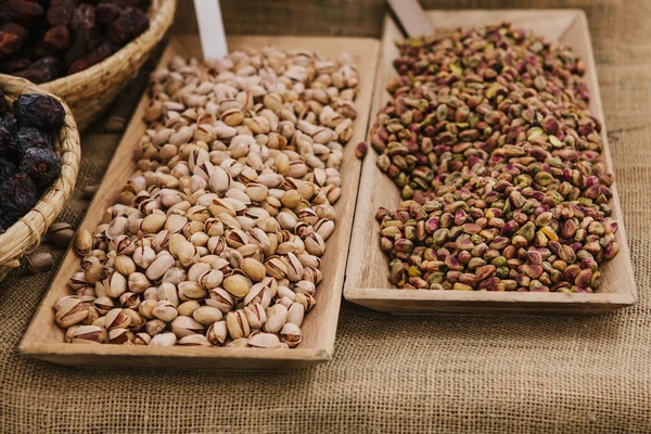 A lot of pistachios are on the table in the store. Useful and tasty nut. — Stock Photo, Image