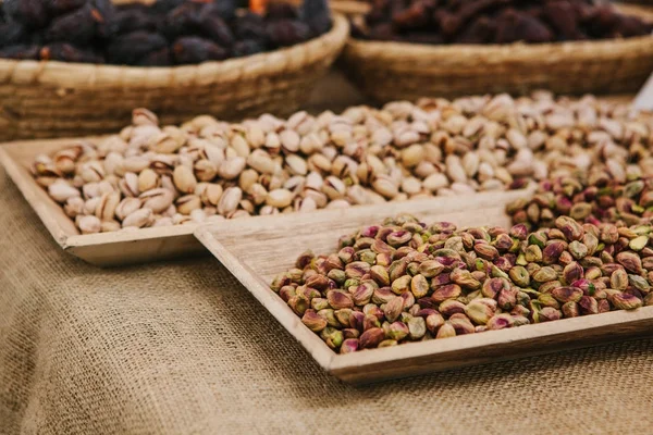 A lot of pistachios are on the table in the store. Useful and tasty nut. — Stock Photo, Image