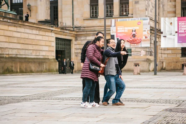 Берлин, 1 октября 2017 года: Группа неизвестных азиатских туристов делают селфи рядом с достопримечательностями на смартфоне — стоковое фото