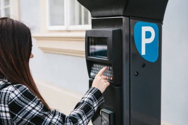 Otopark için ödeme için modern bir terminal. Genç bir kadın bir düğmeye basmadan ve otopark için ödemek istiyor. Günlük yaşamda modern teknoloji.