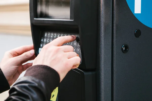 Una moderna terminal para pagar el aparcamiento. La persona presiona los botones y paga por el estacionamiento. Tecnología moderna en la vida cotidiana . — Foto de Stock