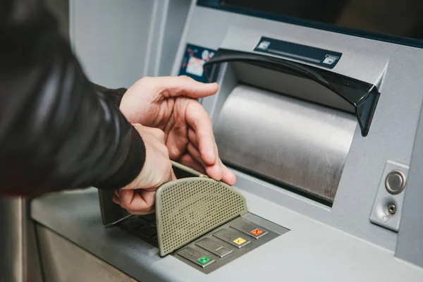 El turista retira dinero del cajero automático para otros viajes. Marca el código con una mano y cierra los botones con la otra mano para proteger la información . — Foto de Stock