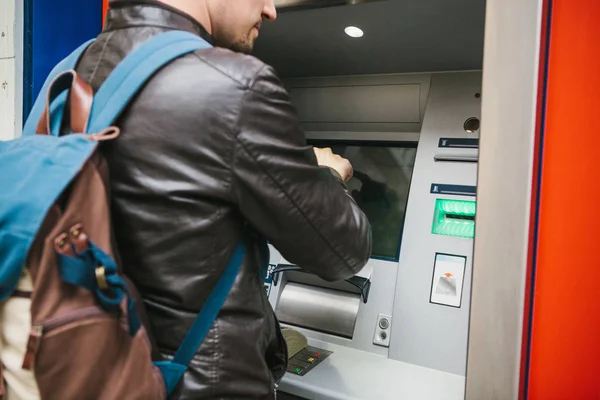 Турист снимает деньги с банкомата для дальнейших поездок. Финансы, кредитка, снятие денег. Путешествие. Отпуск . — стоковое фото