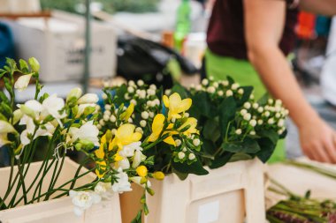 Çiçek satmak için küçük bir iş. Sokak Dükkanı. Satıcı arka planda çalışır. Çiçekler üstünde belgili tanımlık sayaç ön planda farklı türü vardır.
