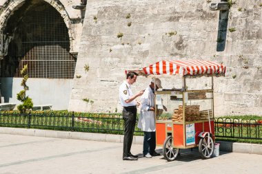 Istanbul, 14 Haziran 2017: Simit denilen geleneksel bir simit satışı. Türk sokak gıda. Polis satın gıda.