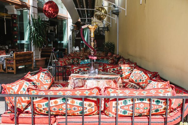 Istanbul, June 16, 2017: Empty Turkish cafe in the traditional style - bright textiles and pillows with hookah standing on the table
