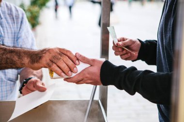 Küçük işletme. Bir adam pişmiş mısır turist ve Istanbul, Türkiye'de yerel halk için satıyor. Alıcı gıda alır ve para verir.
