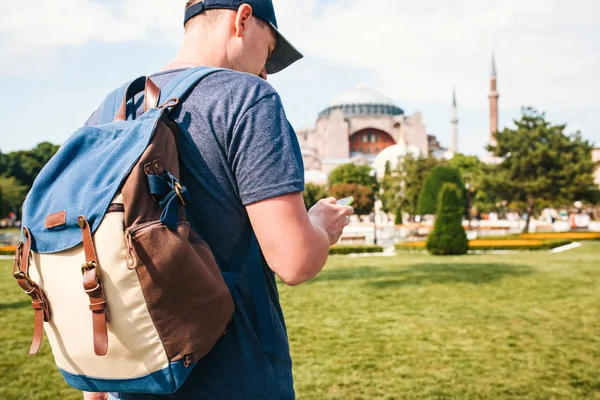 Cestovatel s batohem Sultanahmet náměstí poblíž slavné mešity Hagia Sofia v Istanbulu v Turecku. On se dívá na telefony mapu města a zavolají. Turistika, Památky — Stock fotografie