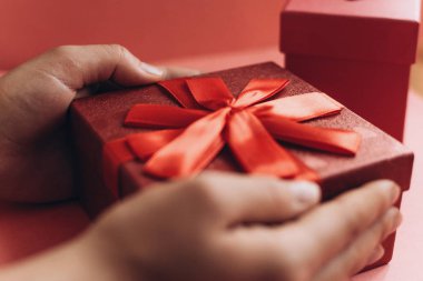 Kız bir hediye bir şerit güzel kırmızı bir kutu aldı ve açmak için gidiyor.