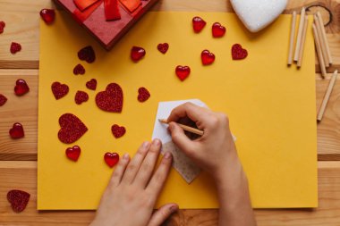 Kız göndermek o, yanında hediye, sembolleri kalpleri ve kalem şeklinde ahşap yüzeyde yalan için tatil Tebrikler olan bir zarf işaretleri.