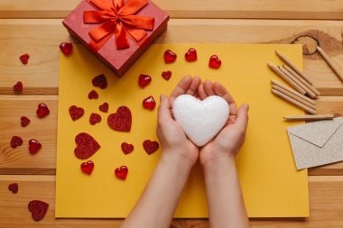 Kız bir kalp şeklinde bir sembol tutuyor ve birisine göndermek için gidiyor. Yakın çeşitli nesneler olay simgeleyen yalan. .