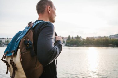 Avrupa'nın Çek Cumhuriyeti Prag evlerin zemin üzerine Nehri yanındaki bir sırt çantası ile turist adam sahanın. Seyahat, gezi, turizm.