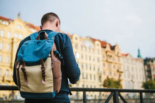 Turistický batoh na pozadí staré architektury v Praze v České republice. On se dívá na mapě. — Stock fotografie