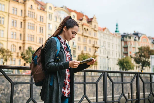 Un turista con una mochila frente a una hermosa arquitectura antigua en Praga en la República Checa. Mira el mapa. . — Foto de Stock