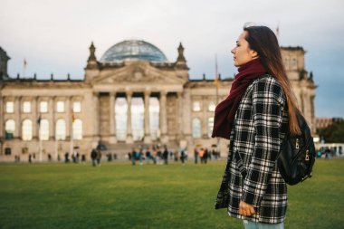 Bir turist kız binanın yanındaki bir sırt çantası ile Almanya'da Berlin Reichstag aradı. Gezi, turizm, seyahat Avrupa