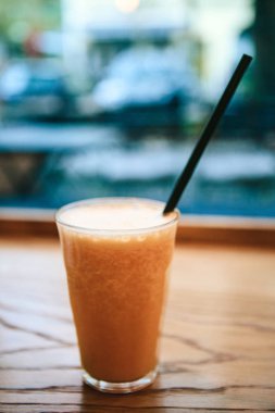 Pencerenin yanındaki bir kafede bir masada taze portakal suyu. Yararlı sabah içki.